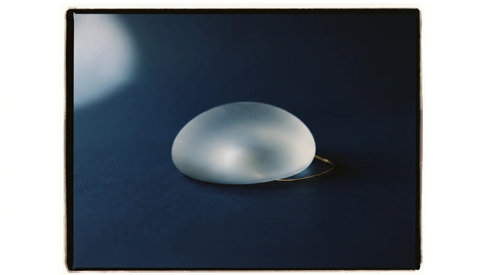 A smooth rounded implant shell catching soft light