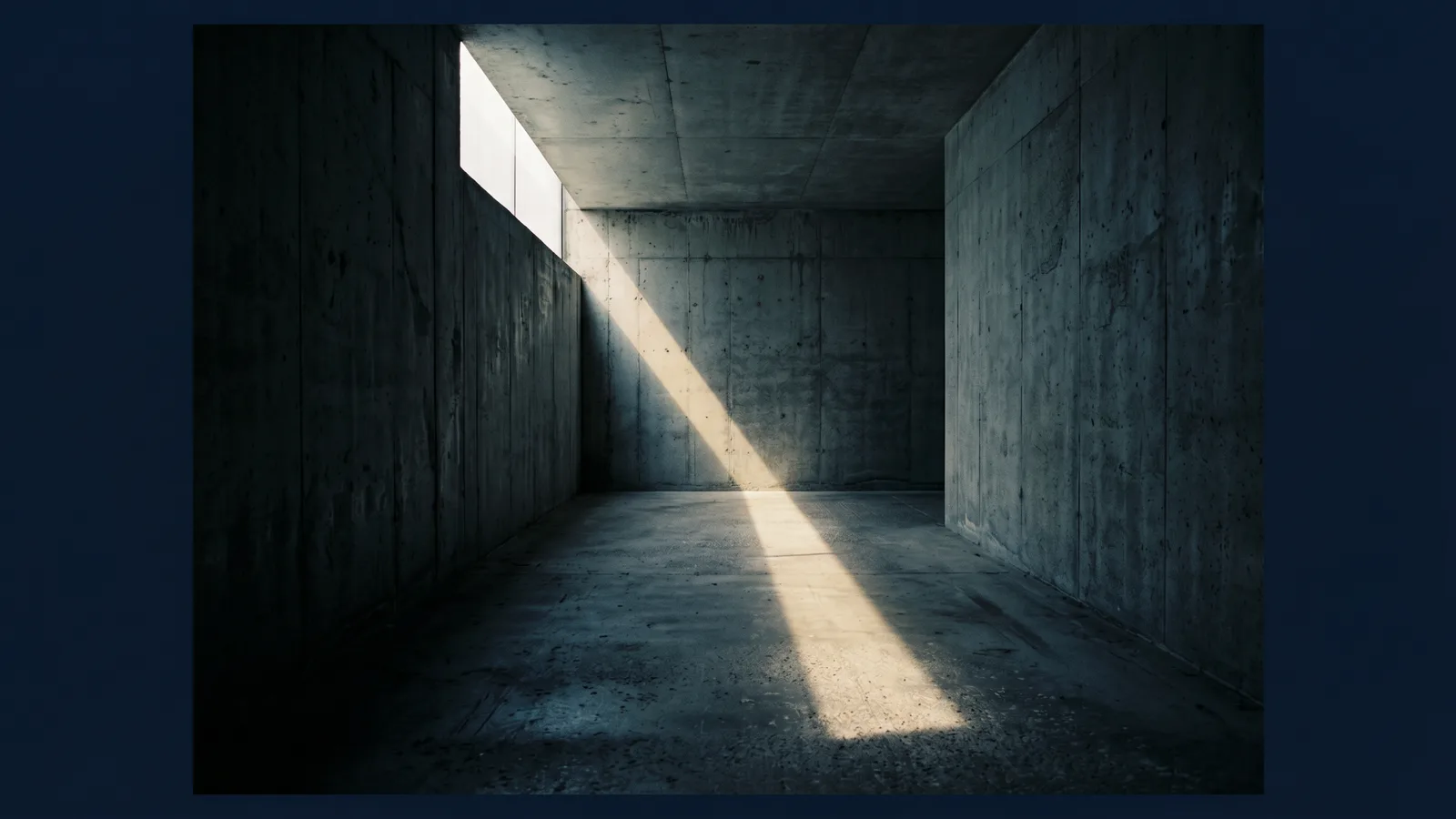 A narrow band of light crossing an empty concrete corridor