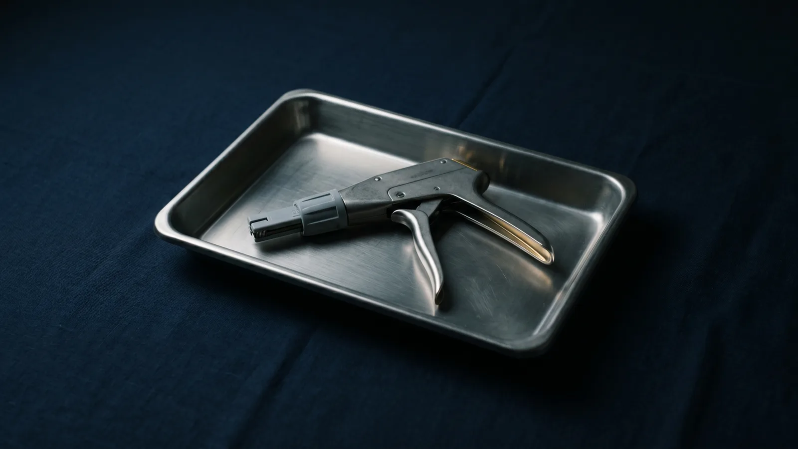 A surgical stapler instrument on a steel tray