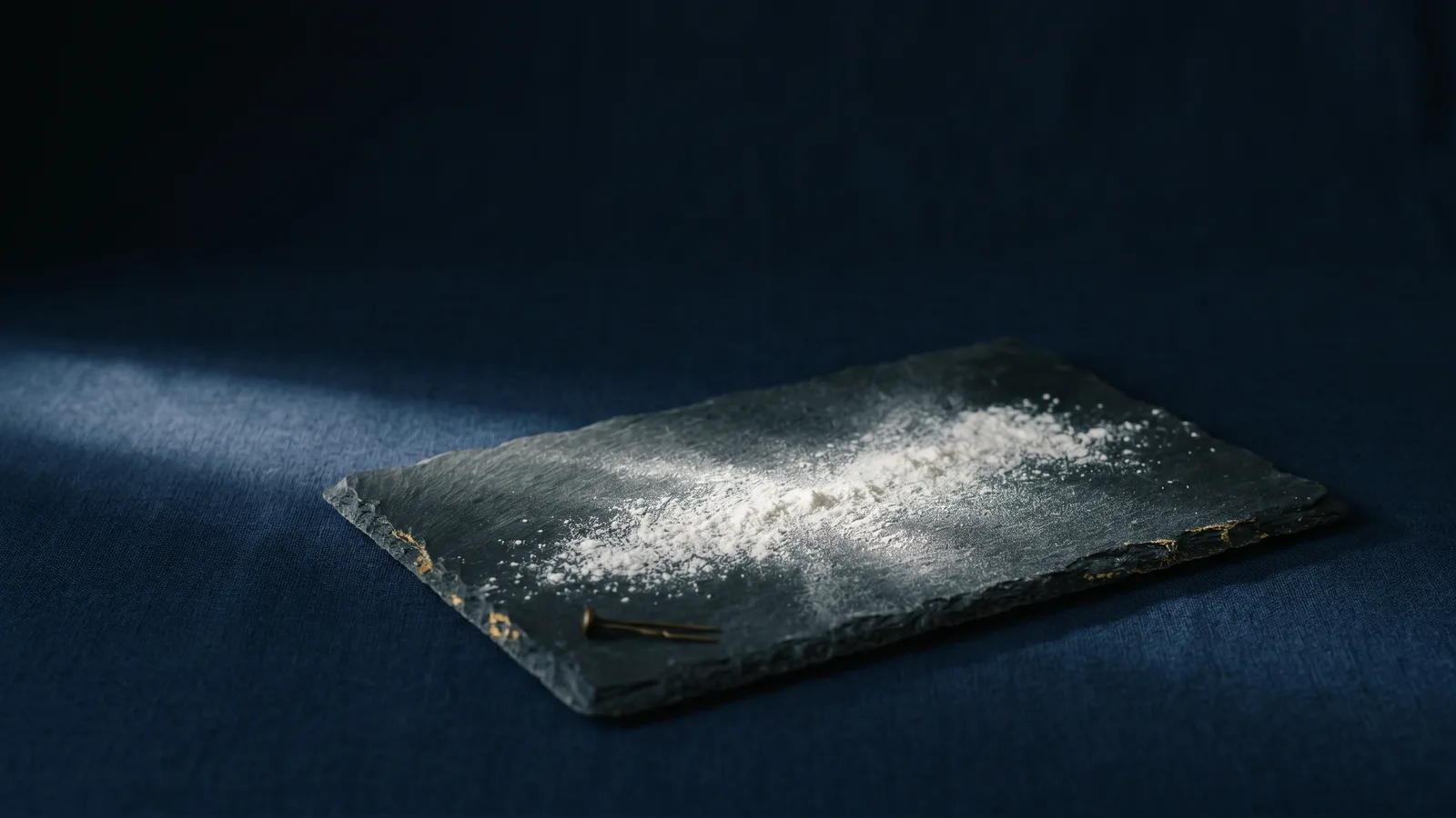 A fine drift of white powder across dark stone