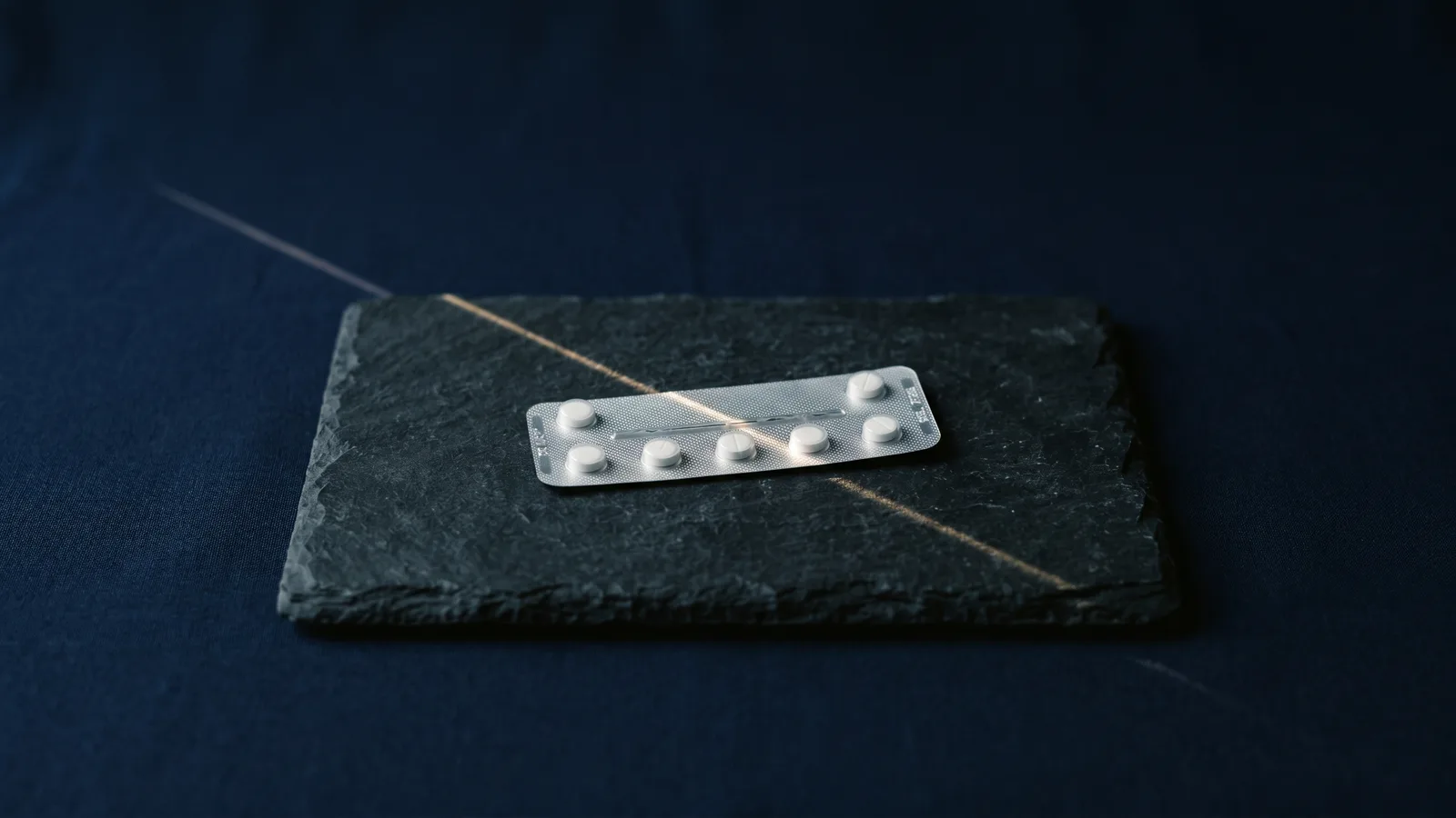 A blister pack crossed by a thin blade of light