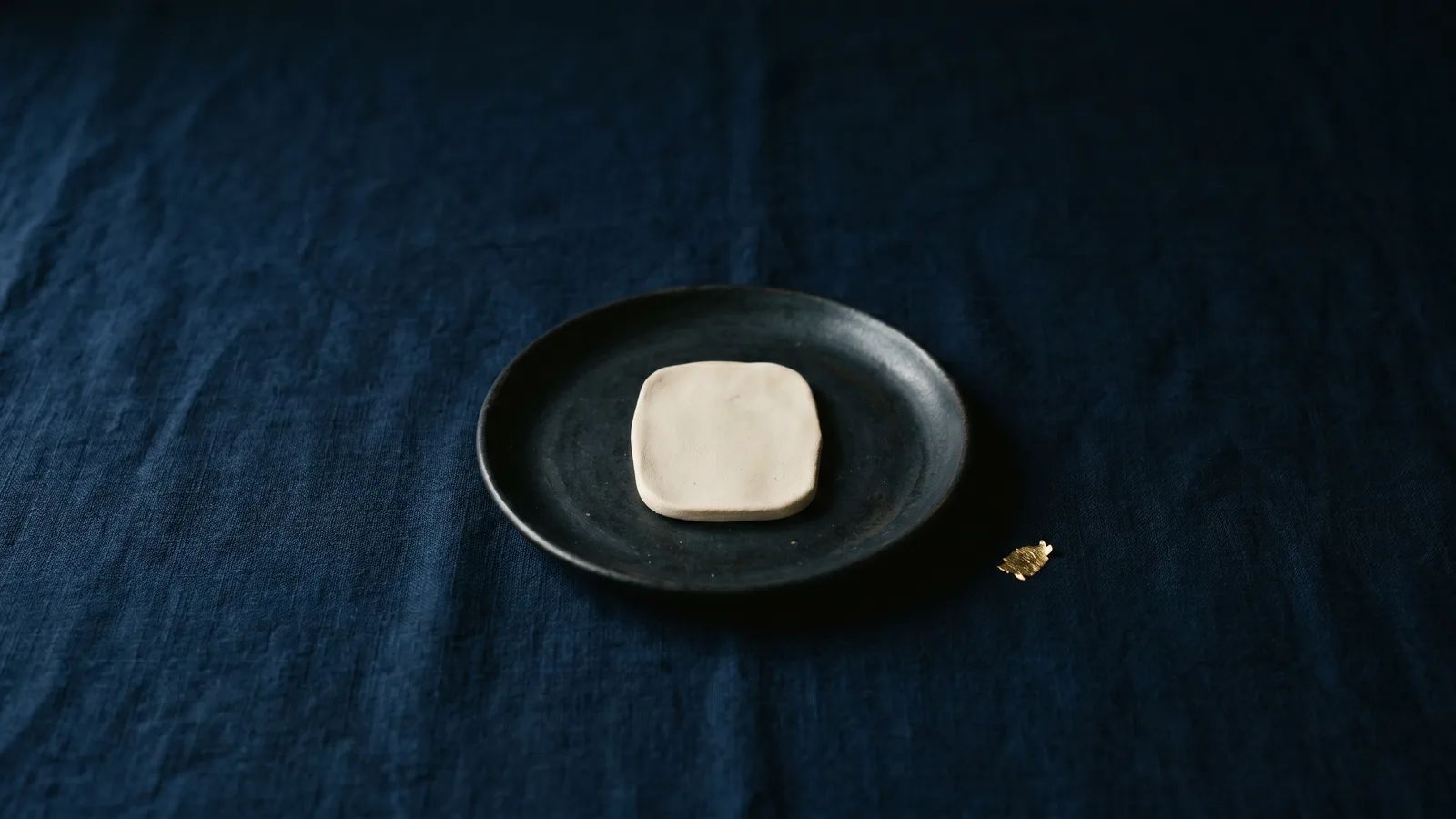 A small pale tablet centered on dark ceramic